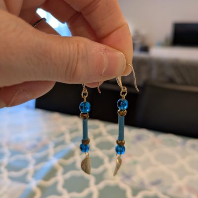 Boucles d'oreilles pendnates en laiton doré, papier washi turquoise, cristaux marrons glacés et perles turquoises terminées par une feuille doré en laiton
